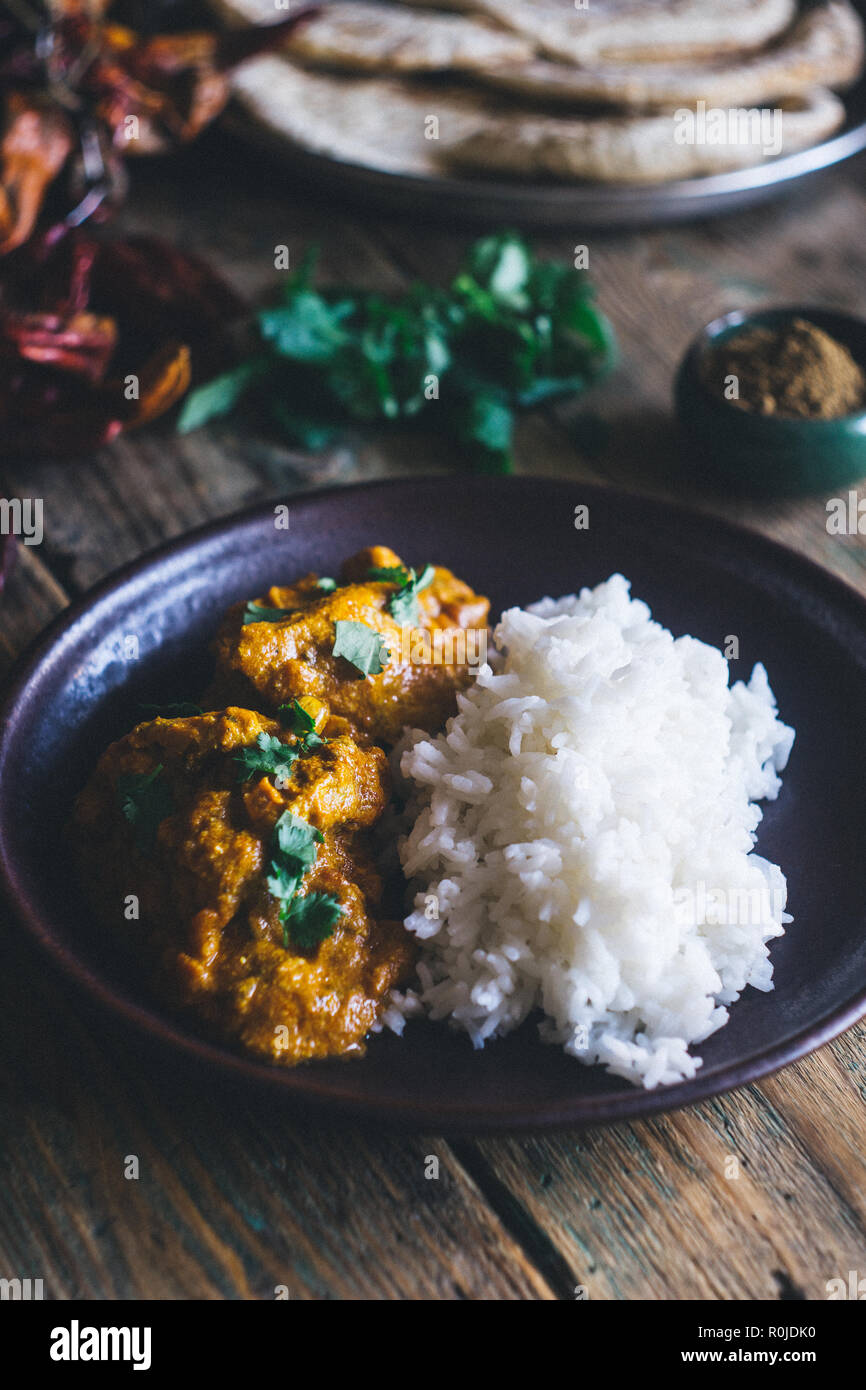 Chicken Tikka Masala (traditionelle indische Curry) mit Reis und indisches Brot chapati mit würzigen roten Paprika, Koriander, indische Gewürze (tu eingerichtet Stockfoto