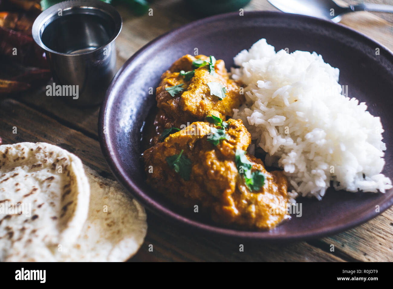 Chicken Tikka Masala (traditionelle indische Curry) mit Reis und indisches Brot chapati mit würzigen roten Paprika, Koriander, indische Gewürze (tu eingerichtet Stockfoto