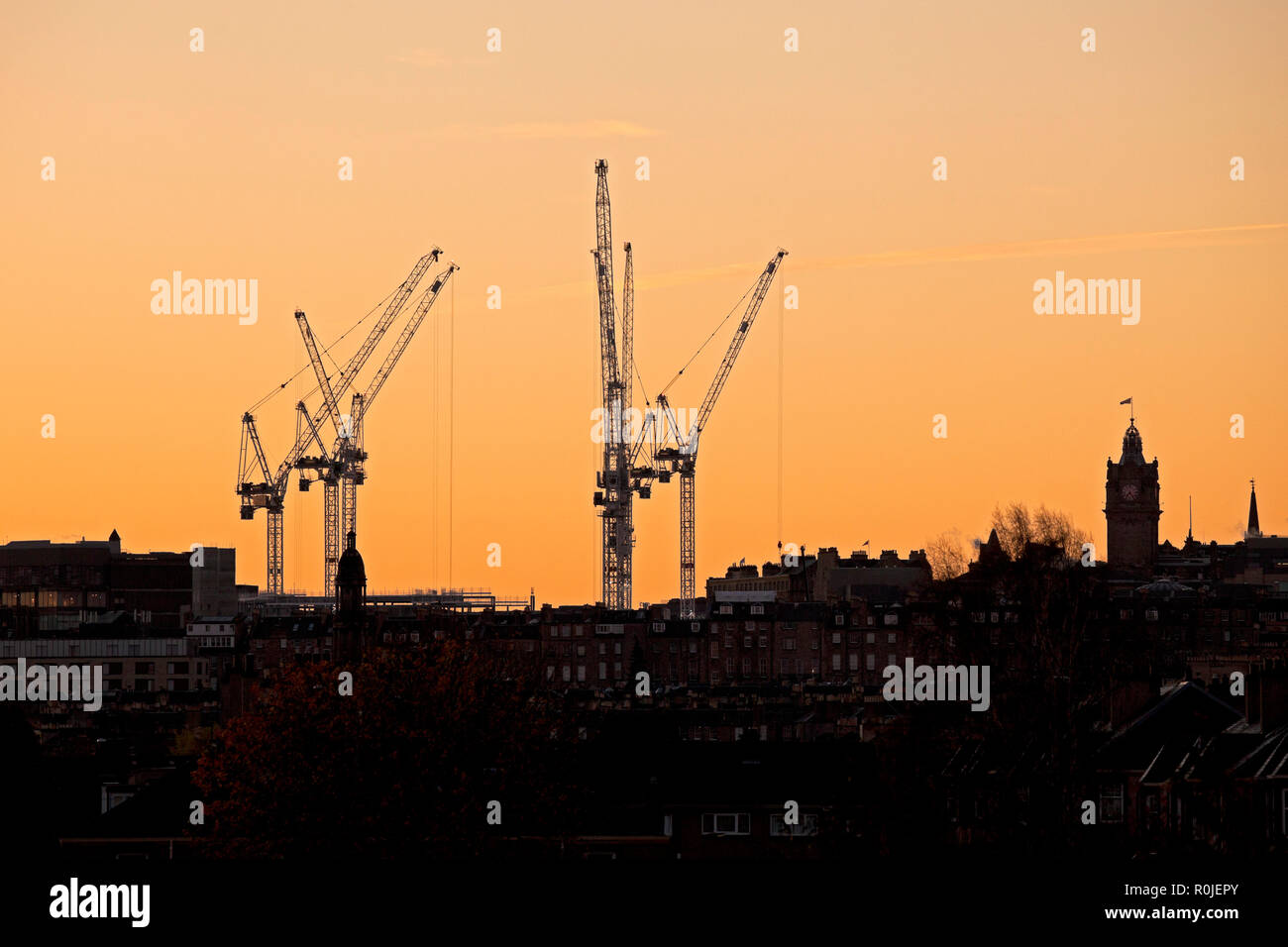Industriekrane im Stadtzentrum von Edinburgh 2018 gegen Sonnenaufgang Himmel silhouetted, Princes Street, Edinburgh, Schottland, Großbritannien Stockfoto