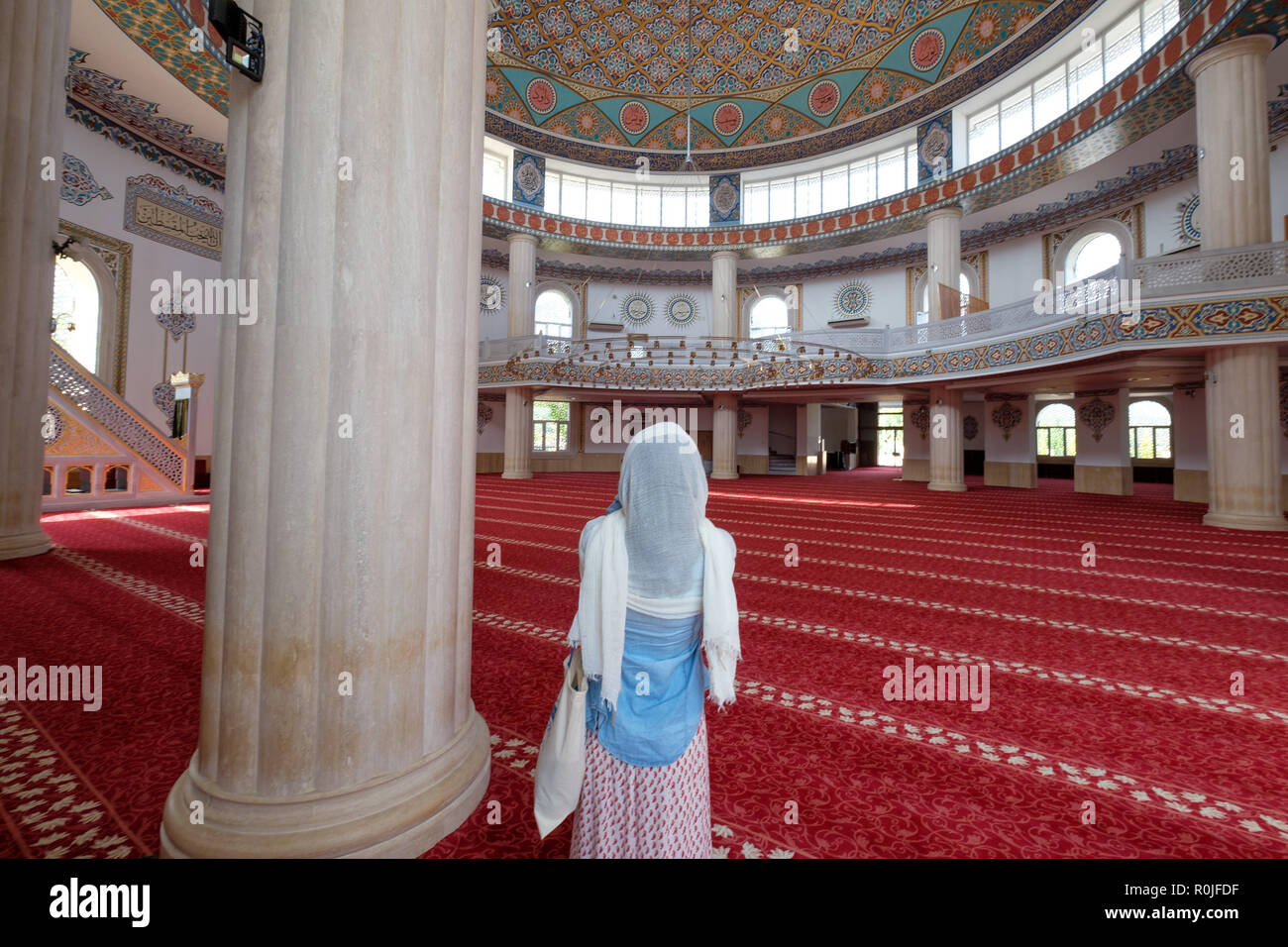 Ansicht der Rückseite eine Frau trägt einen Schal auf dem Kopf im Huzur Cami islamische Moschee in Kemer, Provinz Antalya, Türkei Stockfoto