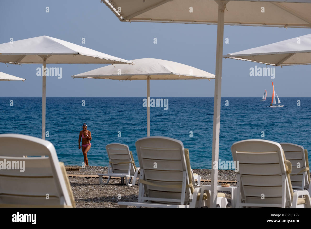 Tan Frau aus dem Wasser am Kiesstrand im Club Med Palmiye Luxus all inclusive Resort, Kemer, Antalya, Türkei Stockfoto
