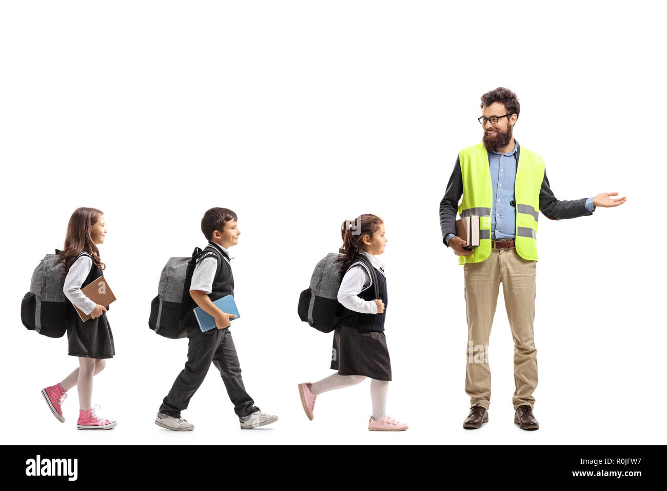 Volle Länge Profil Aufnahme von Schülern zu Fuß in einer Linie und einer Lehrerin und deutete mit der Hand auf weißem Hintergrund Stockfoto