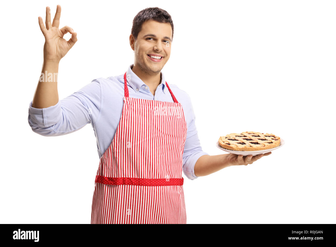 Junger Mann mit einer Torte und deutete mit der Hand auf weißem Hintergrund Stockfoto
