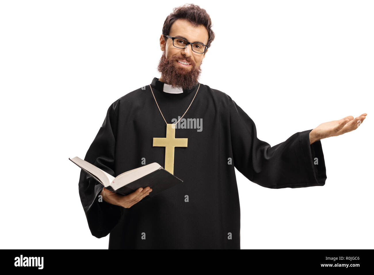Junge Priester eine offene Bibel und deutete mit der Hand auf weißem Hintergrund Stockfoto