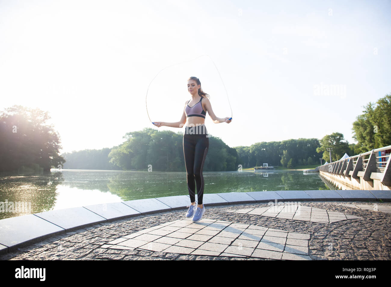 Porträt von Fit junge Frau mit Springseil in einem Park. Fitness Frauen  springen Training im Freien an einem sonnigen Tag zu tun Stockfotografie -  Alamy