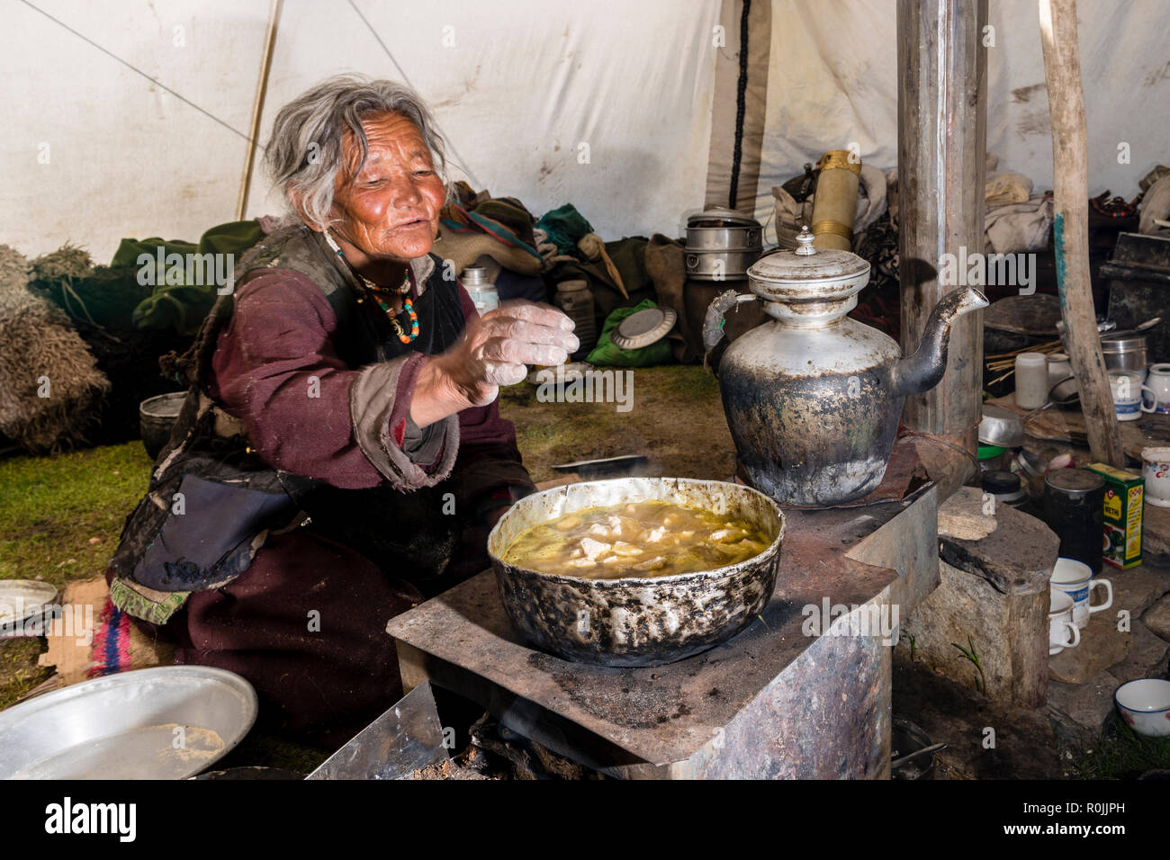 Ein Nomade Frau ist die Zubereitung von Speisen in ihr Zelt aufgeschlagen, auf einer Höhe von 4.600 m über dem Meeresspiegel in der Nähe Tso Moriri Changtang. Stockfoto
