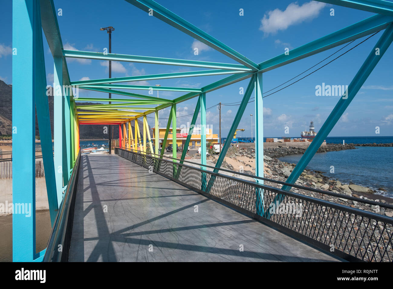 Regenbogenfarbige Brücke mit Ozean Hintergrund - bunte Stahlbrücke Stockfoto
