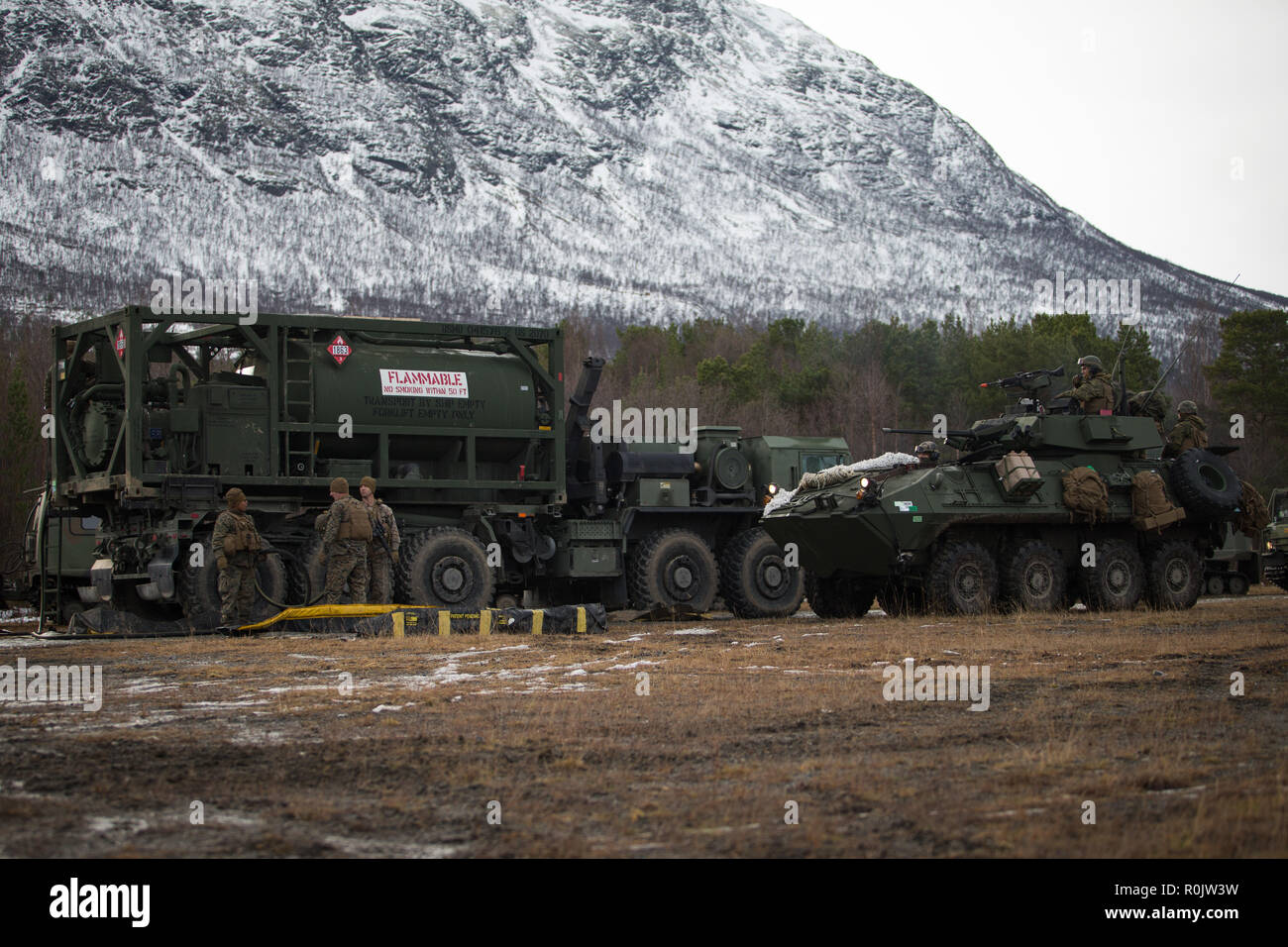 Us-Marines mit Transport Services Unternehmen, die Bekämpfung der Logistik Bataillon 2, 2 Marine Logistik Group-Forward, warten Sie ein leicht gepanzertes Fahrzeug mit 2. Light Armored Reconnaissance Bataillon (LAR), 2nd Marine Division in Oppdal, Norwegen, Nov. 2, 2018 zu tanken. Die Marines sofern Kraftstoff, Wasser und Essen, bereit zum 2. LAR, 4 LAR und norwegische Verbündeten während der Übung Trident Punkt 18 zu essen. Die Übung verbessert die USA und die NATO-Verbündeten und Fähigkeiten der Partner zur Zusammenarbeit militärische Operationen unter schwierigen Bedingungen durchzuführen. (U.S. Marine Corps Foto von Sgt. Bet Stockfoto