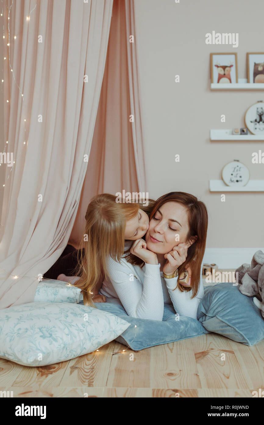 Kleines Mädchen küsste ihre Mutter auf Neues Jahr Stockfoto