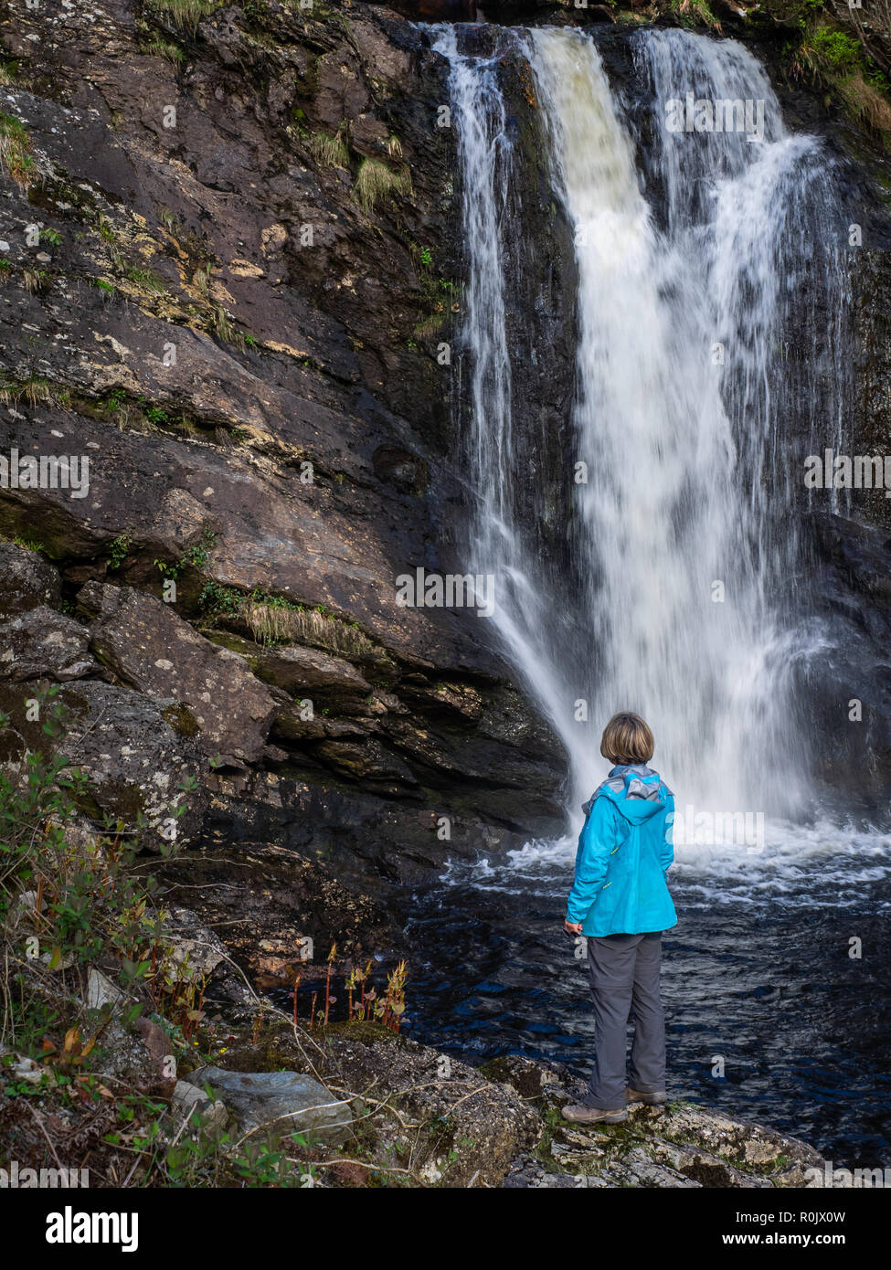 Eine reife Lady am Wasserfall auf ein mountian Wanderung in den schottischen Highlands Stockfoto