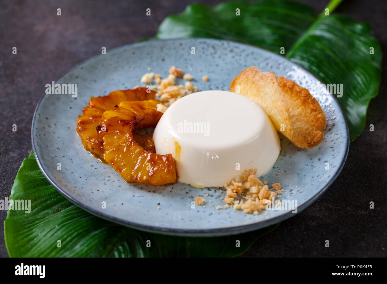 Panna cotta mit karamellisierter Ananas und Kokosnuss Keks Stockfoto