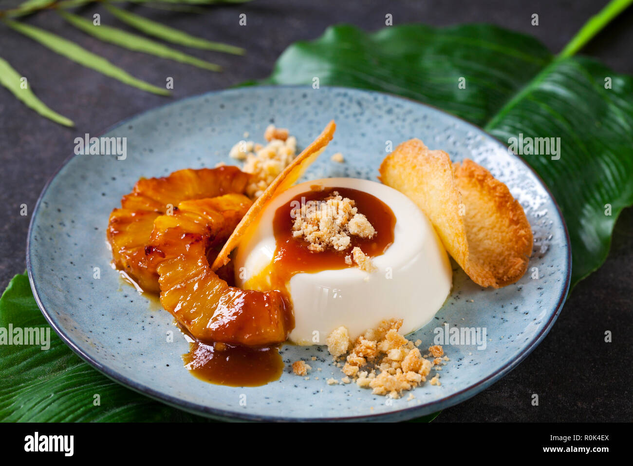 Panna cotta mit karamellisierter Ananas und Kokosnuss Keks Stockfoto