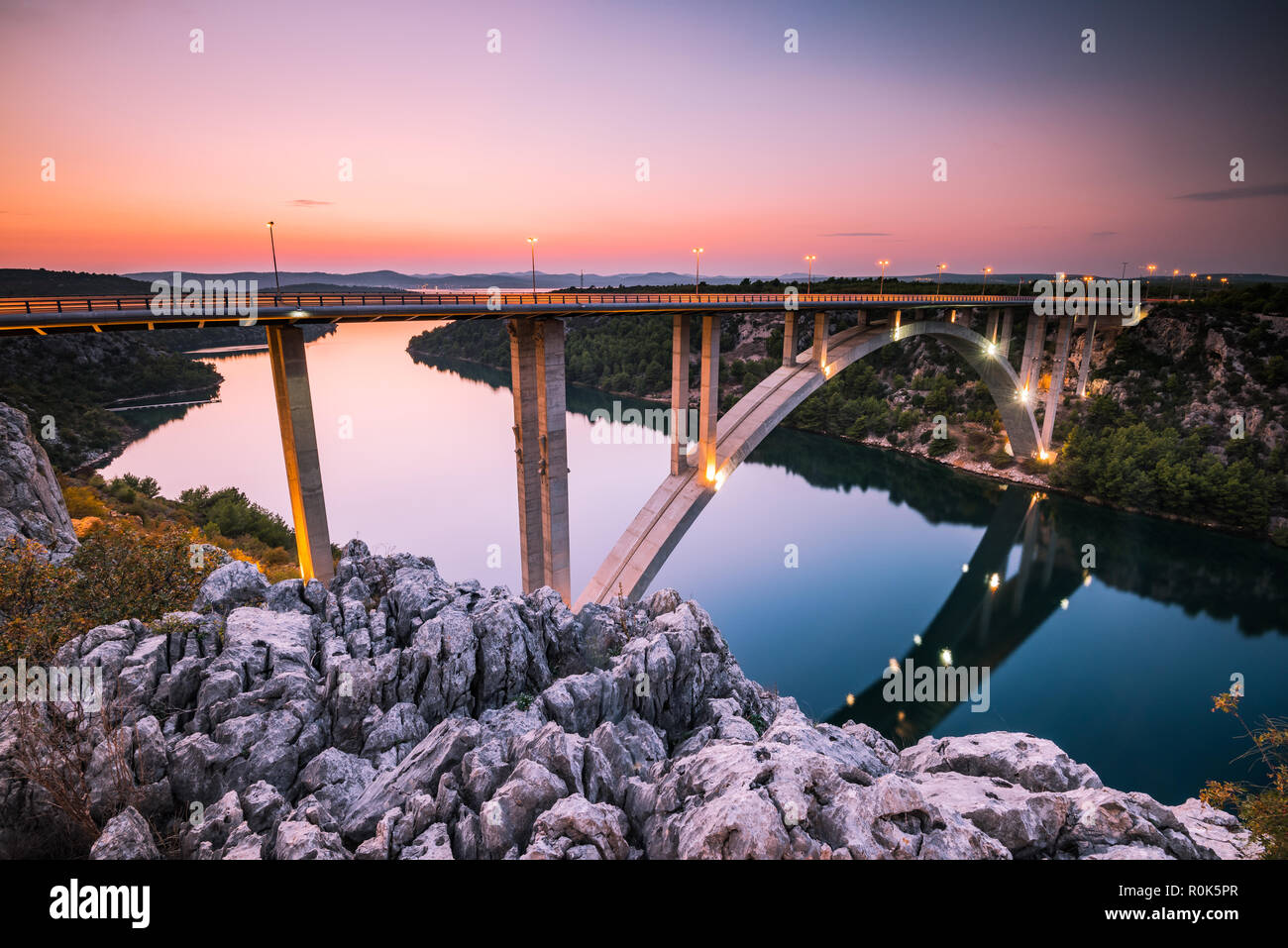 Sibenik Brücke über den Fluss Krka leuchtet an der blauen Stunde, in der Nähe von Skradin Dorf in Kroatien. Stockfoto