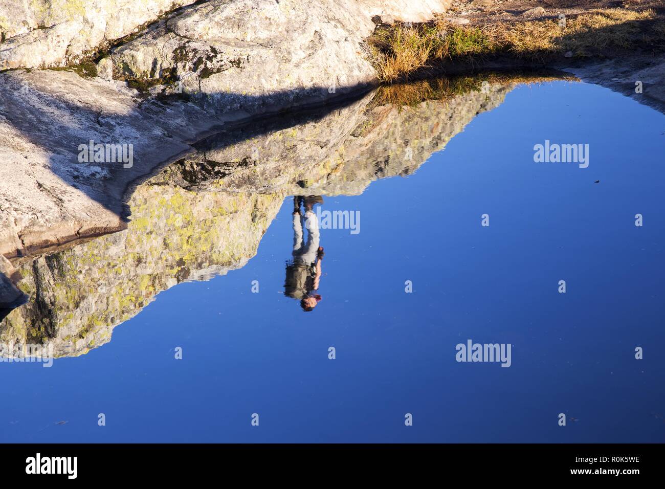 Nach oben Wanderer Silhouette spiegelt sich in immer noch Wasser aus Granit Spalte auf Mount Seymour Peak, North Shore Mountains vor Vancouver, BC, Kanada Stockfoto