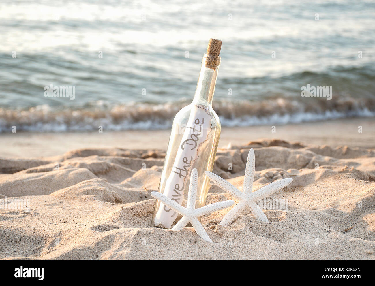 Weiße Seesterne Paar in Strand Sand mit Datum speichern Nachricht in einer Flasche Stockfoto