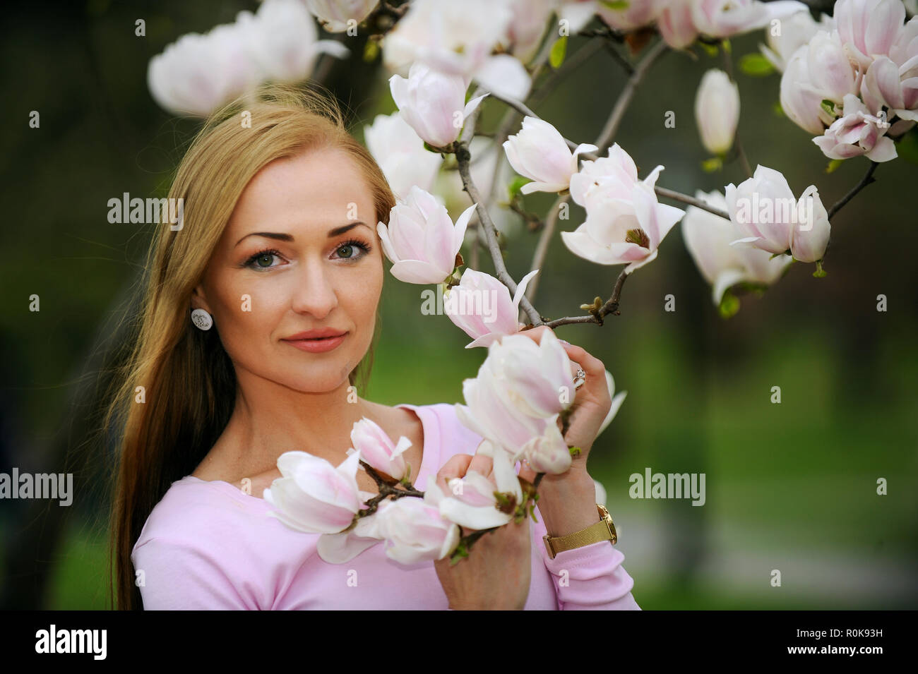 Schöne, Schöne und junge Frau an die Blüten der Bäume im Frühling. Stockfoto