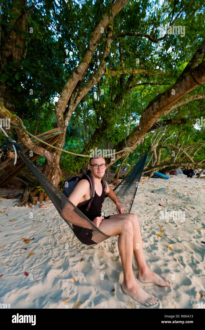 Jungen Touristen entspannen auf Swing onTeluk Blue Coral Beach auf Pangkor Island in Malaysia. Schöne Landschaft mit Blick aufs Meer in Südostasien. Stockfoto