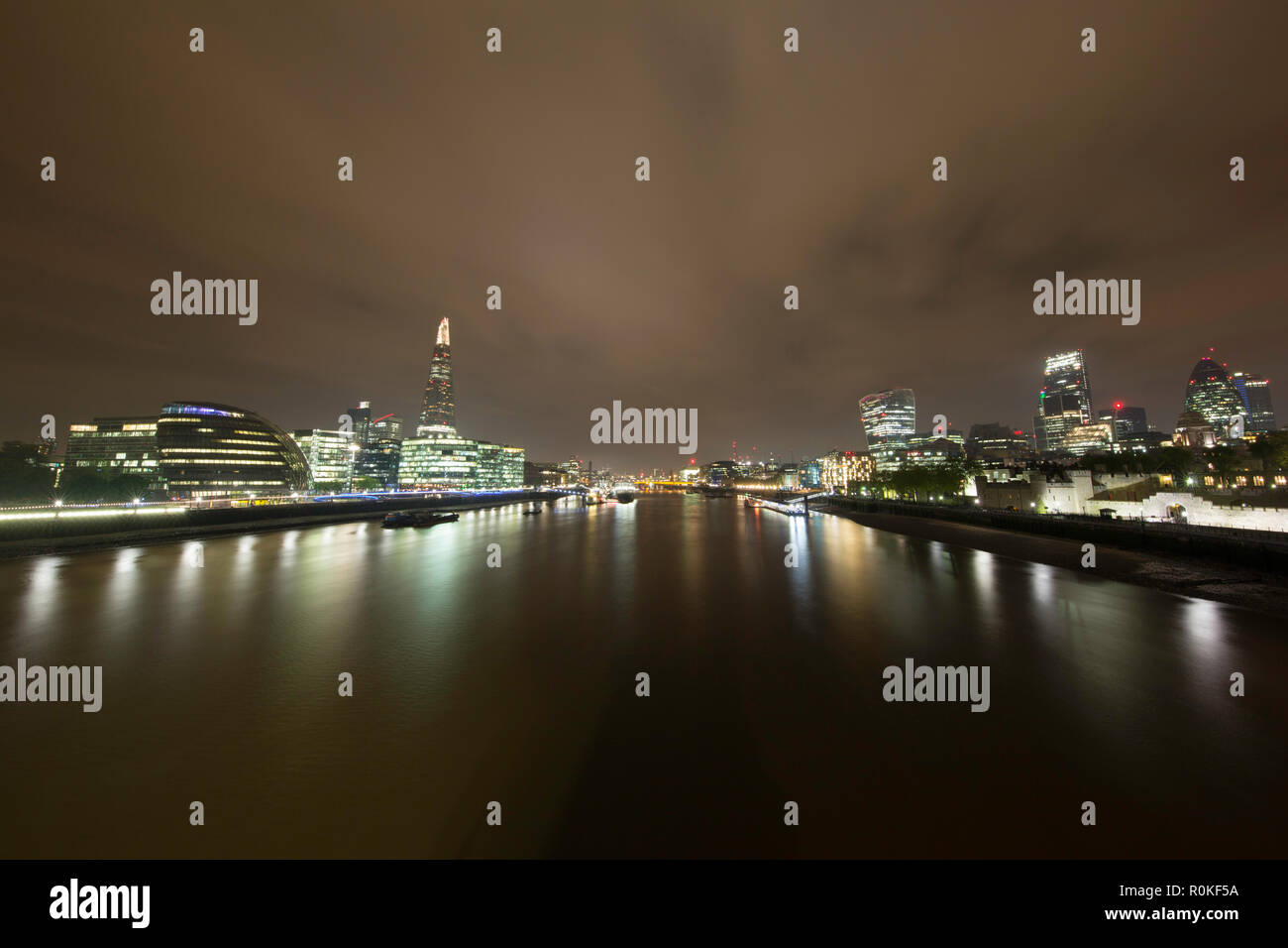 Die City von London bei Nacht Blick nach Westen von der Tower Bridge, London, England Stockfoto