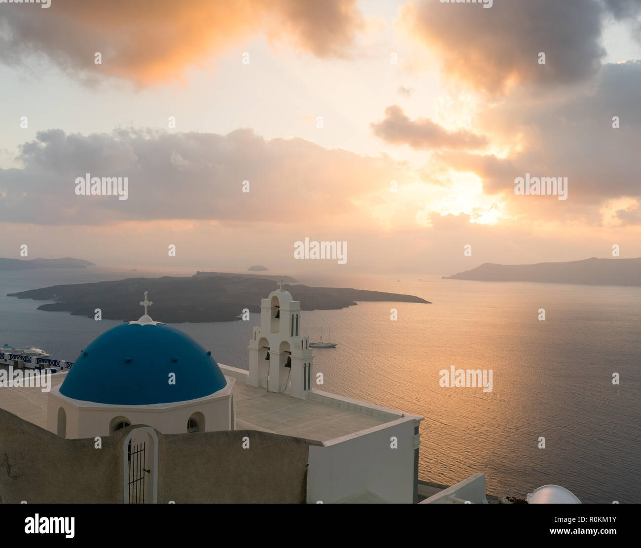 Sonnenuntergang über der Ägäis mit Blick auf die Jungfrau Maria Katholische Kirche drei Glocken von Fira, Santorini. Stockfoto