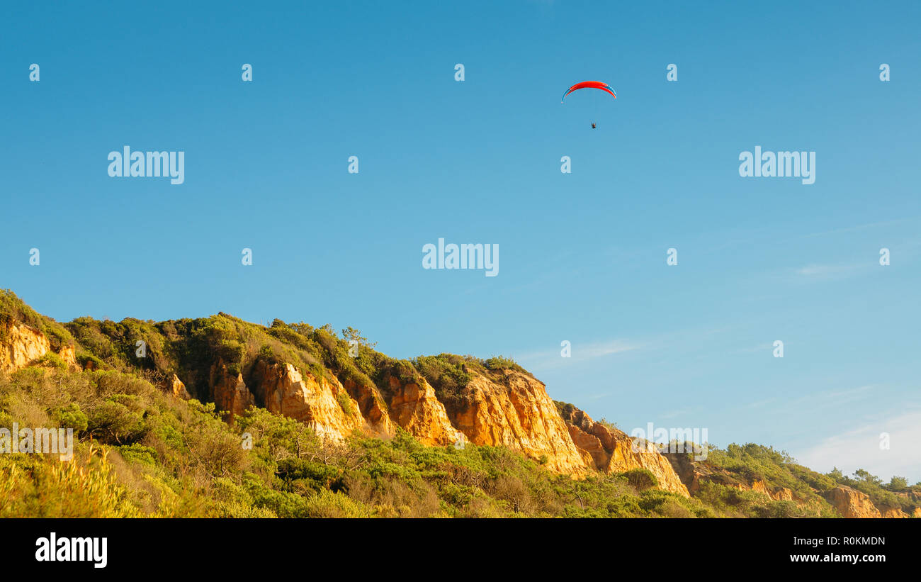 Eine Person mit einem Fallschirm gleiten auf dem Hintergrund der blauen Himmel, in Caparica, Portugal erfasst Stockfoto