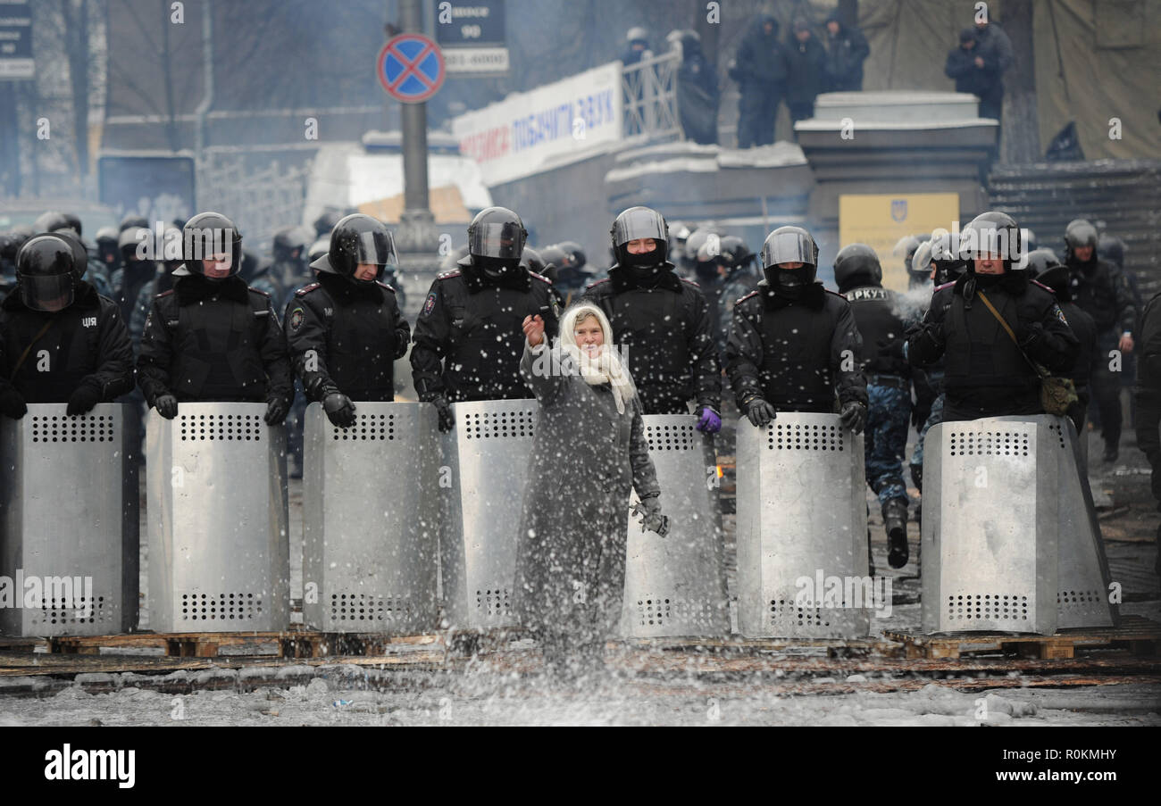 Januar 28, 2014 - Kiew, Ukraine: ukrainische frau Flügel zeichen Lesungen ama' ('Mums") gehen Sie in das Niemandsland und versuchen Sie, die Situation als Tausende von Verärgerten regierungsfeindlichen Demonstranten Gesicht Bereitschaftspolizei aus ihren Barrikaden in der Nähe von Independence Square zu beschwichtigen. Diesen Teil des Stadtzentrum von Kiew wurde verwüstet, nach schweren Auseinandersetzungen zwischen Demonstranten, brennende Reifen und die Polizei mit Wasserwerfern bei Minusgraden Demonstranten Barrikaden Polizei vom Stürmen Maidan, dem Kiewer Platz der Unabhängigkeit, das Epizentrum der Revolte gegen die Regierung zu verhindern. Des meres ukrainiennes penetren Stockfoto