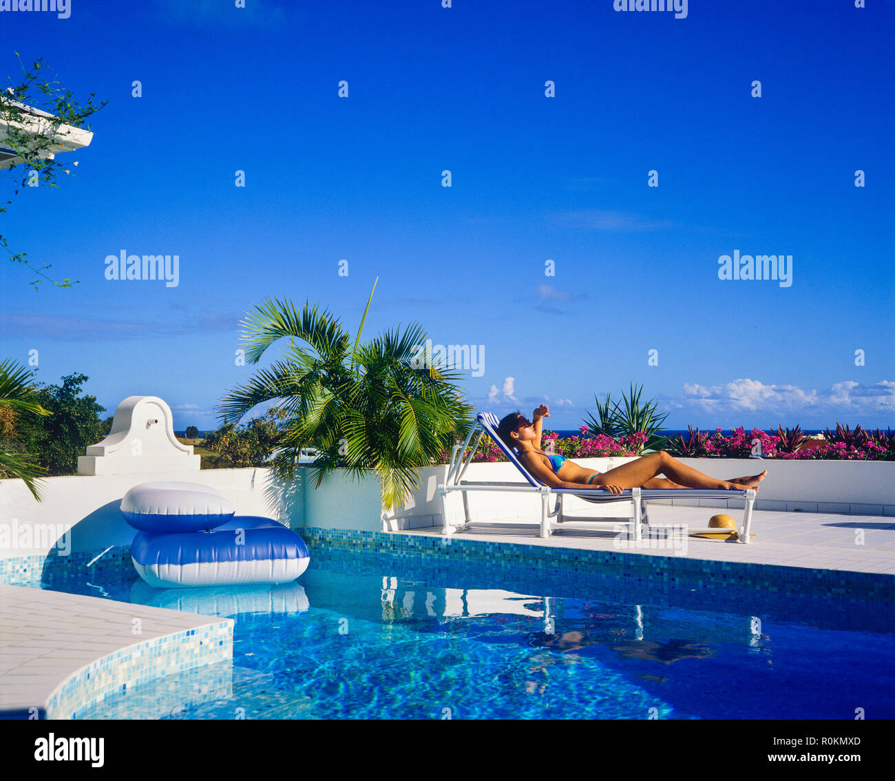 Junge Frau mit blauen Bikini Sonnenbaden auf Sonnenliegen am Pool, Swimmingpool, Guadeloupe, Französisch Westindien, Stockfoto
