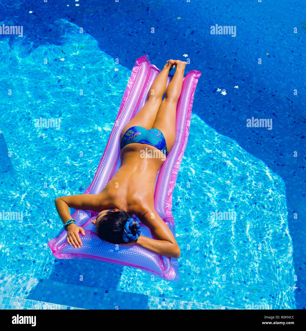 Blick von oben auf eine oben ohne junge Frau, die sich auf einem rosa Luftmatratzenschweller sonnt, Swimmingpool, Guadeloupe, Französisch-Westindien, kleine Antillen, Stockfoto