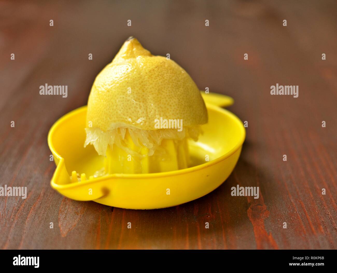 Die Hälfte der gelbe Zitrone Entsaften auf braunen Tisch Hintergrund. Nahaufnahme Stockfoto