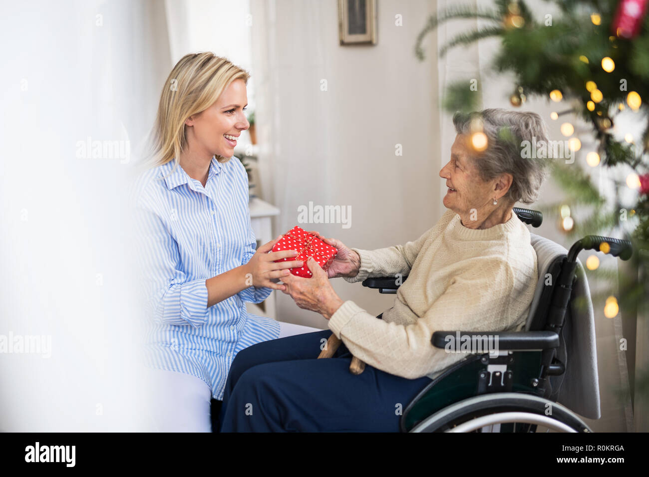 Gesundheit Besucher Und Altere Frau Im Rollstuhl Mit Einem Geschenk Weihnachten Zuhause Stockfotografie Alamy
