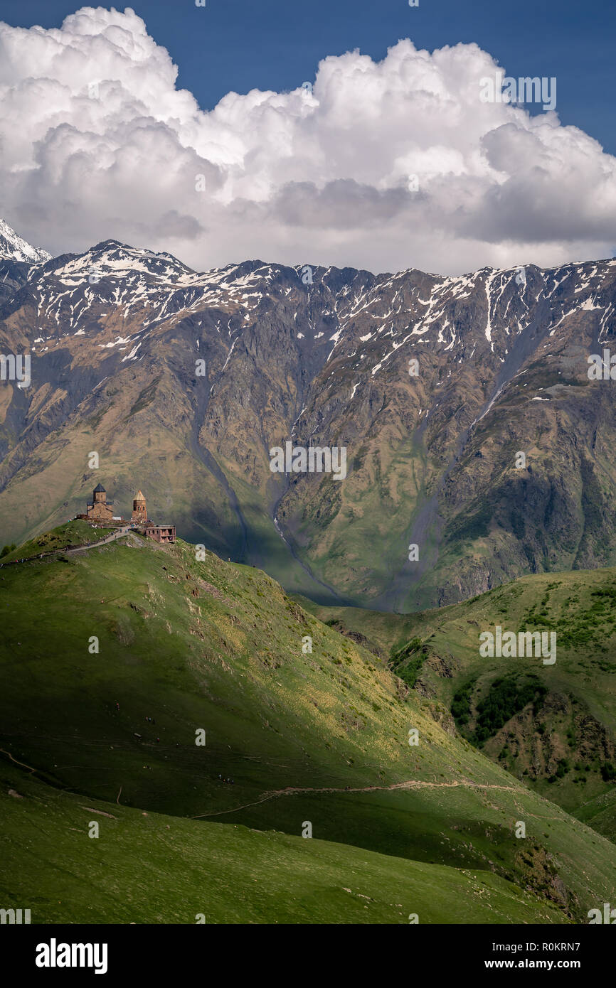 Gergeti Kirche drastisch thront auf einem Hügel im Kaukasus, in Kazbegi, Georgia. Stockfoto