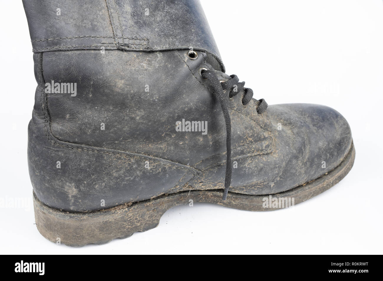 Alte schwarze schmutzige Schuhe. Leder militärischen Schuhe auf einem weißen Tisch. Hellen Hintergrund. Stockfoto