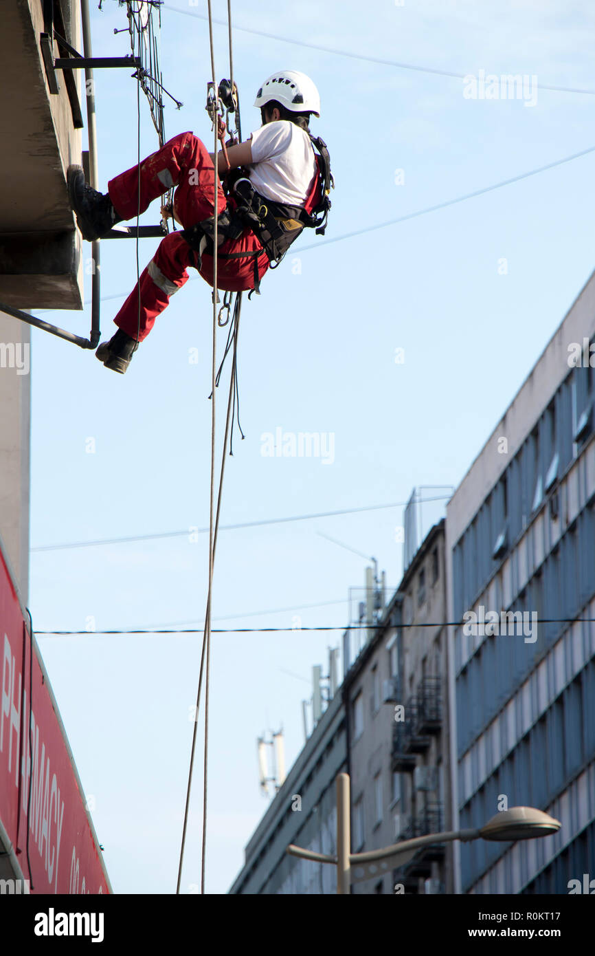 Belgrad, Serbien - November 19, 2018: industriekletterer am Seil hängend während der Installation von Werbebanner auf einer Bilding, Low Angle View Stockfoto