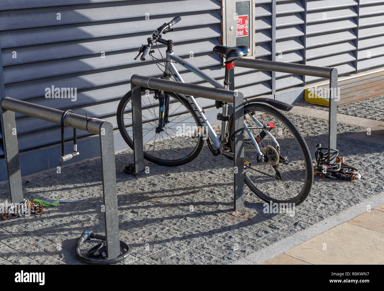 Ein Fahrrad zu einem Fahrradträger in MediaCityUK, Salford Quays gesperrt. Stockfoto