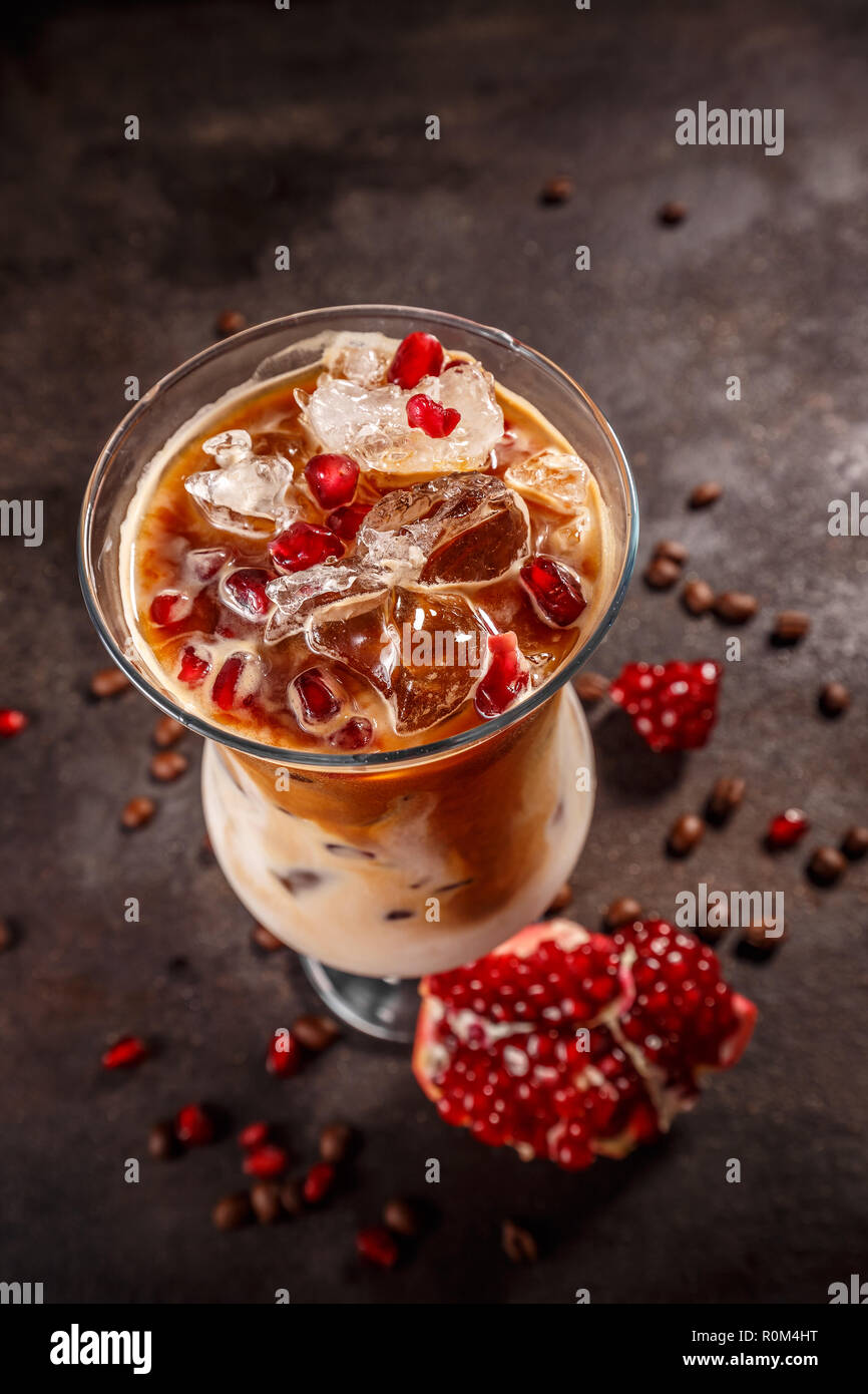 Eiskaffee mit Milch in hohes Glas aromatisiert mit Granatapfel Sirup Stockfoto