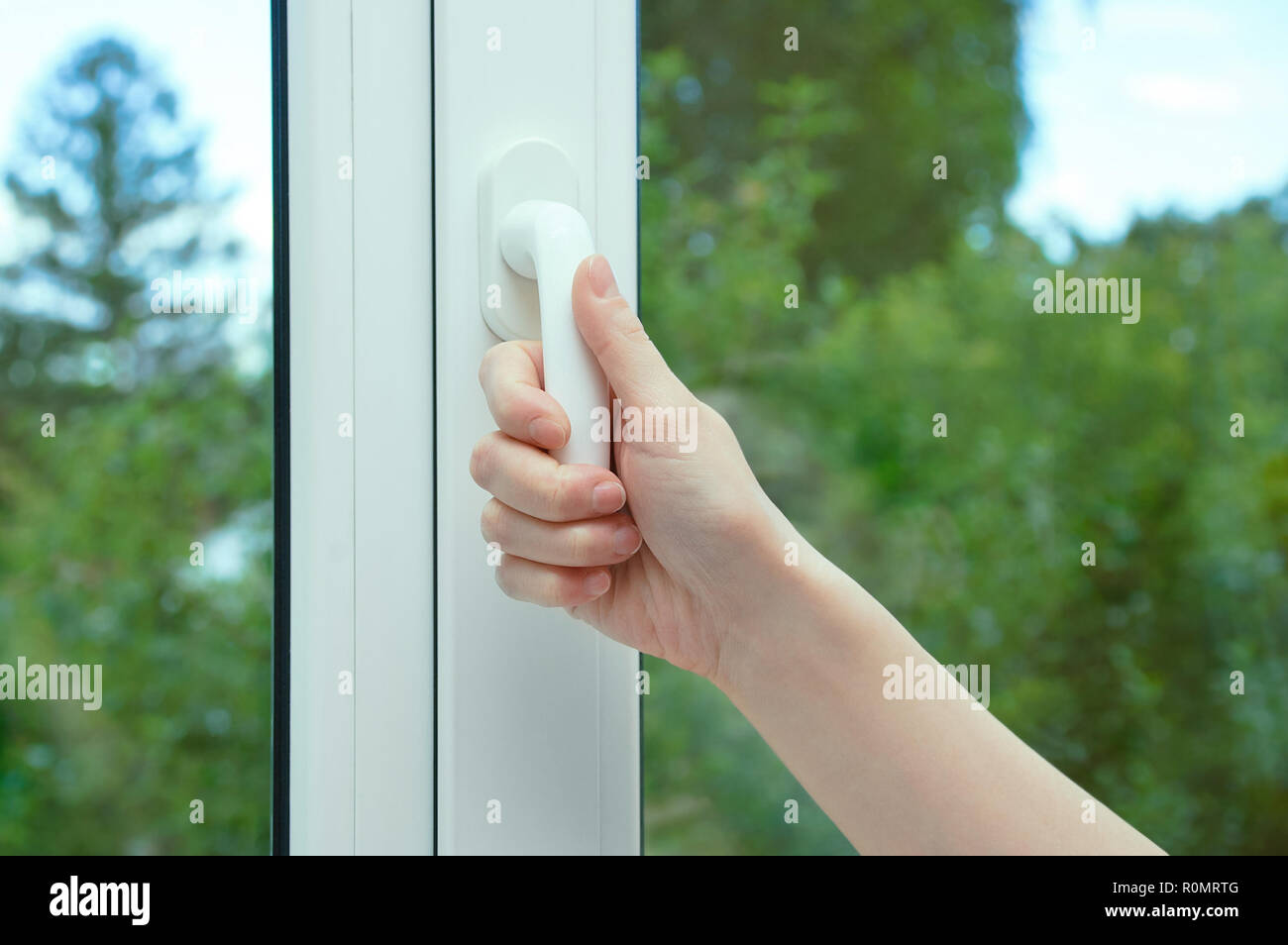 Eine Frau öffnet den Flügel des Fensters. Close-up. Stockfoto