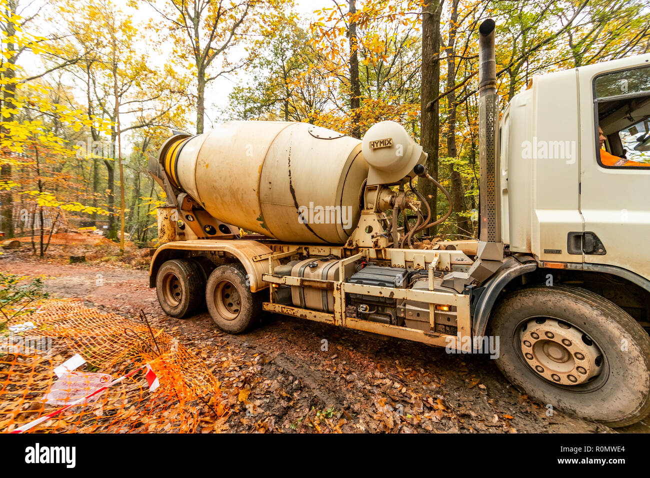 Beton gießt - Eine konkrete Lkw liefert zu einem wartenden Betonpumpe im Wald während der Bau einer neuen Skulptur. Stockfoto