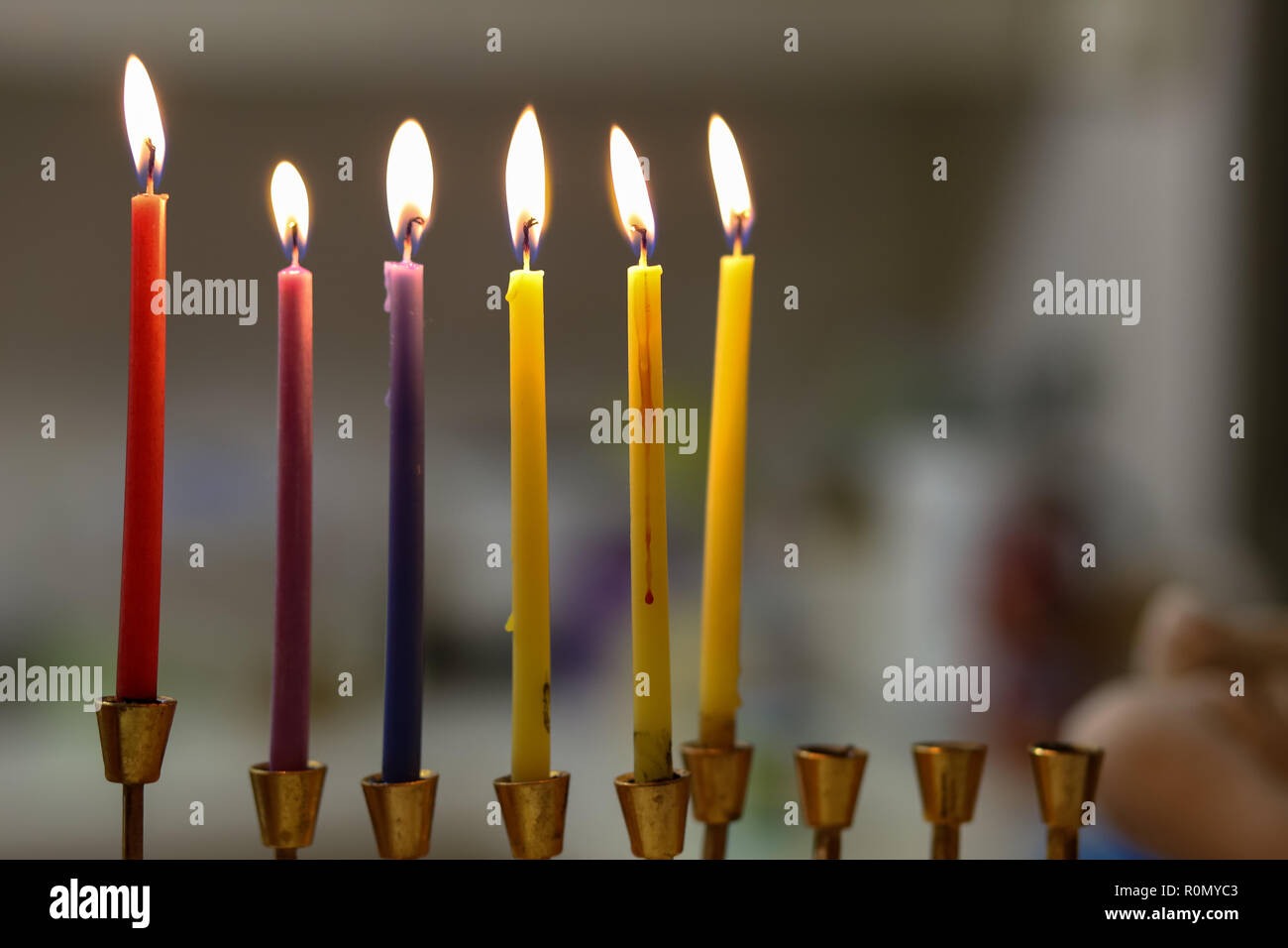 Bunte Chanukah Kerzen in einem goldenen menorah Stockfoto