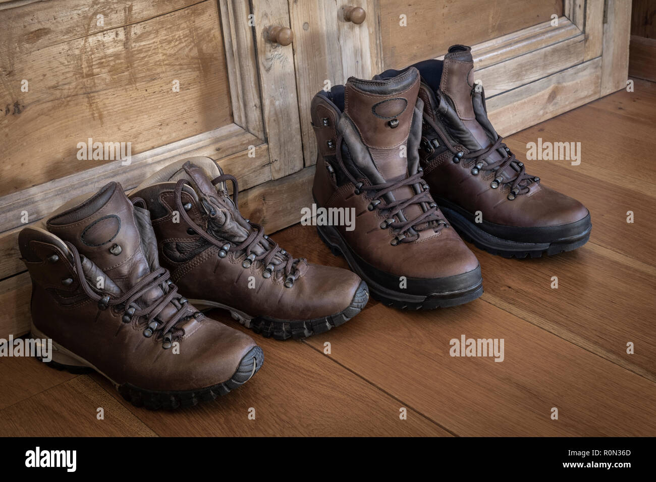 Zwei Paare aus Leder Wanderschuhe auf einem Holzboden. Stockfoto