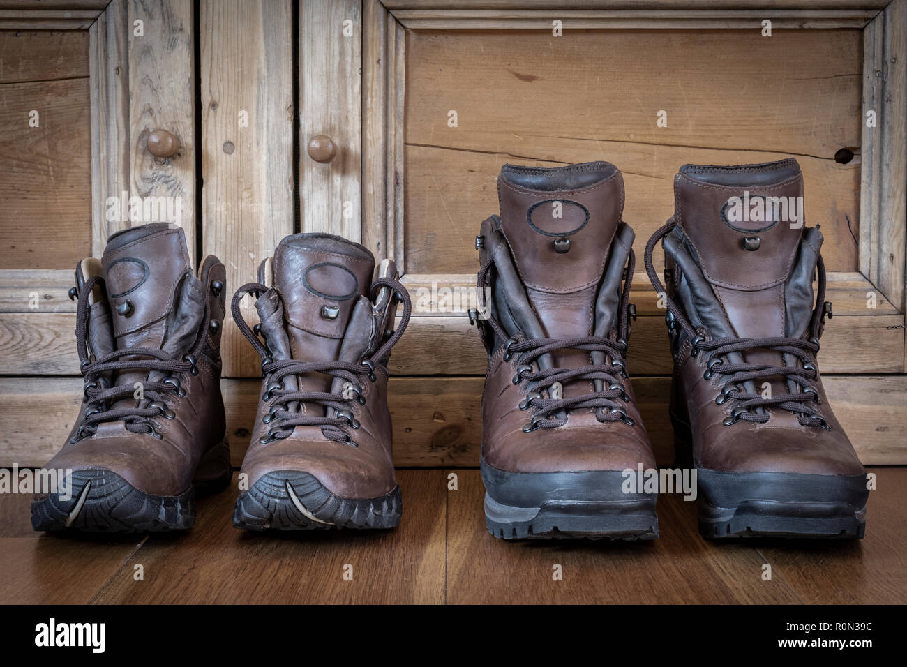 Zwei Paare aus Leder Wanderschuhe auf einem Holzboden. Stockfoto