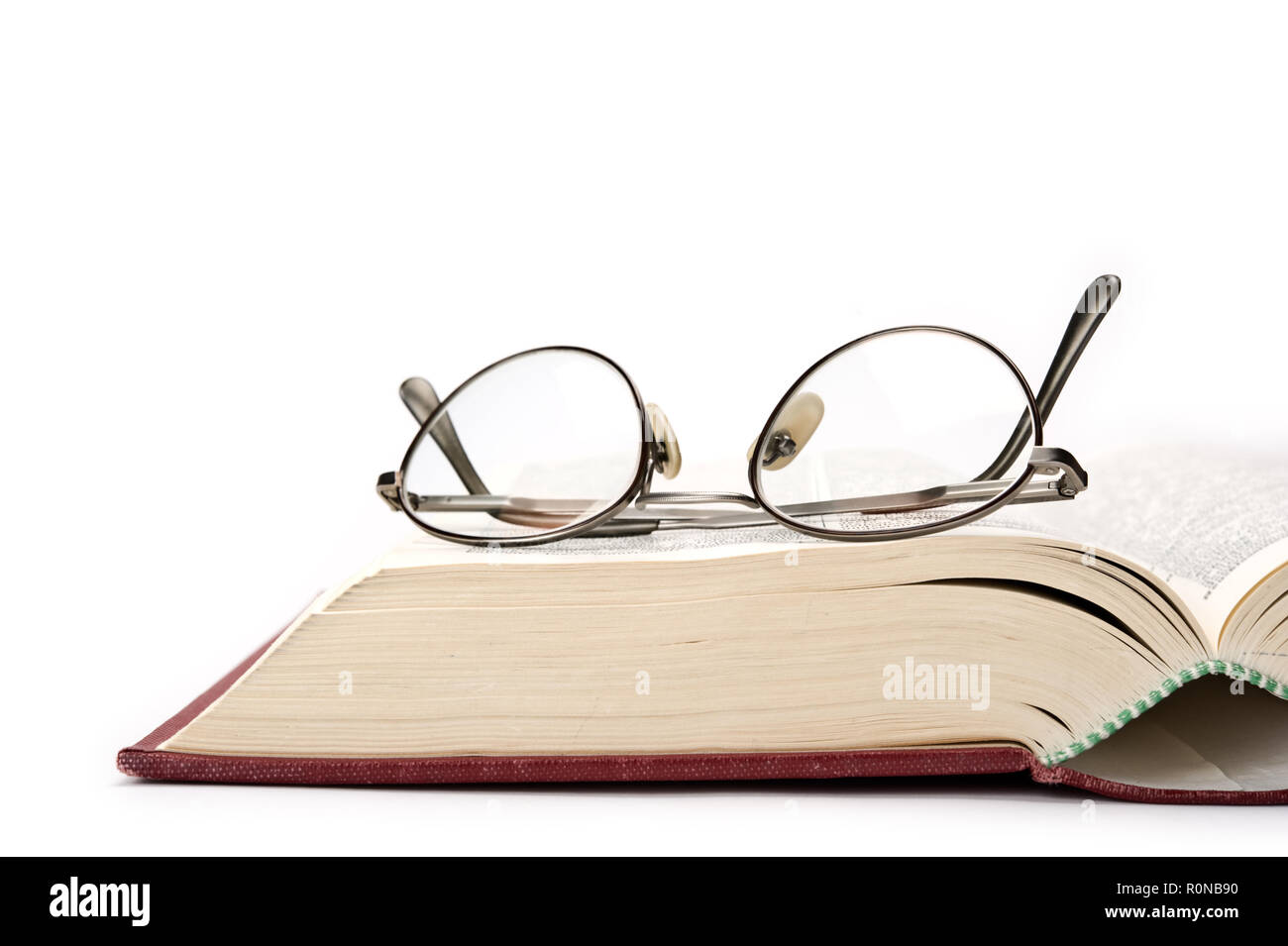 Buch und Gläser auf weißem Hintergrund. Stockfoto
