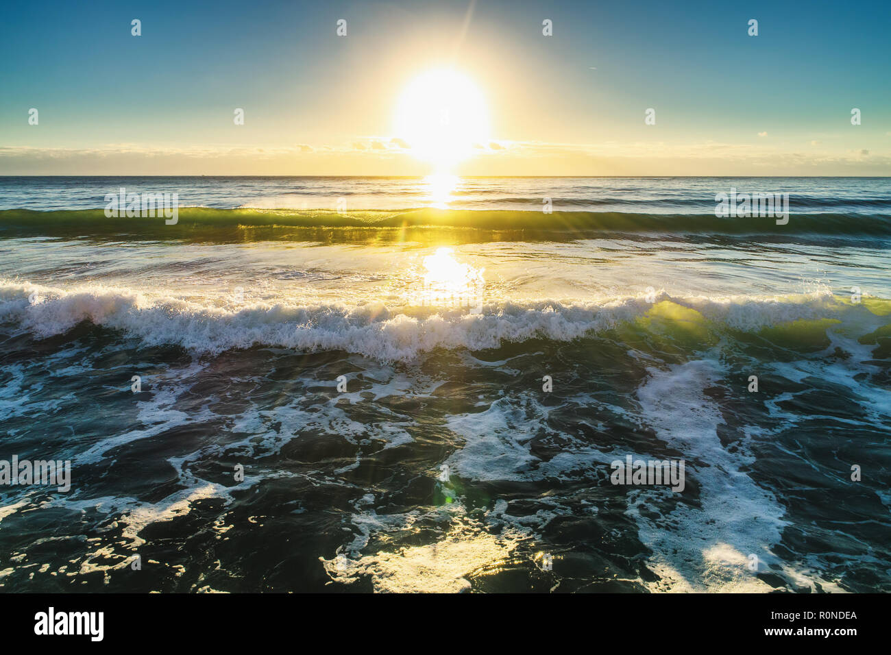 Luftaufnahme der Wellen des Ozeans bei Sonnenaufgang Stockfoto