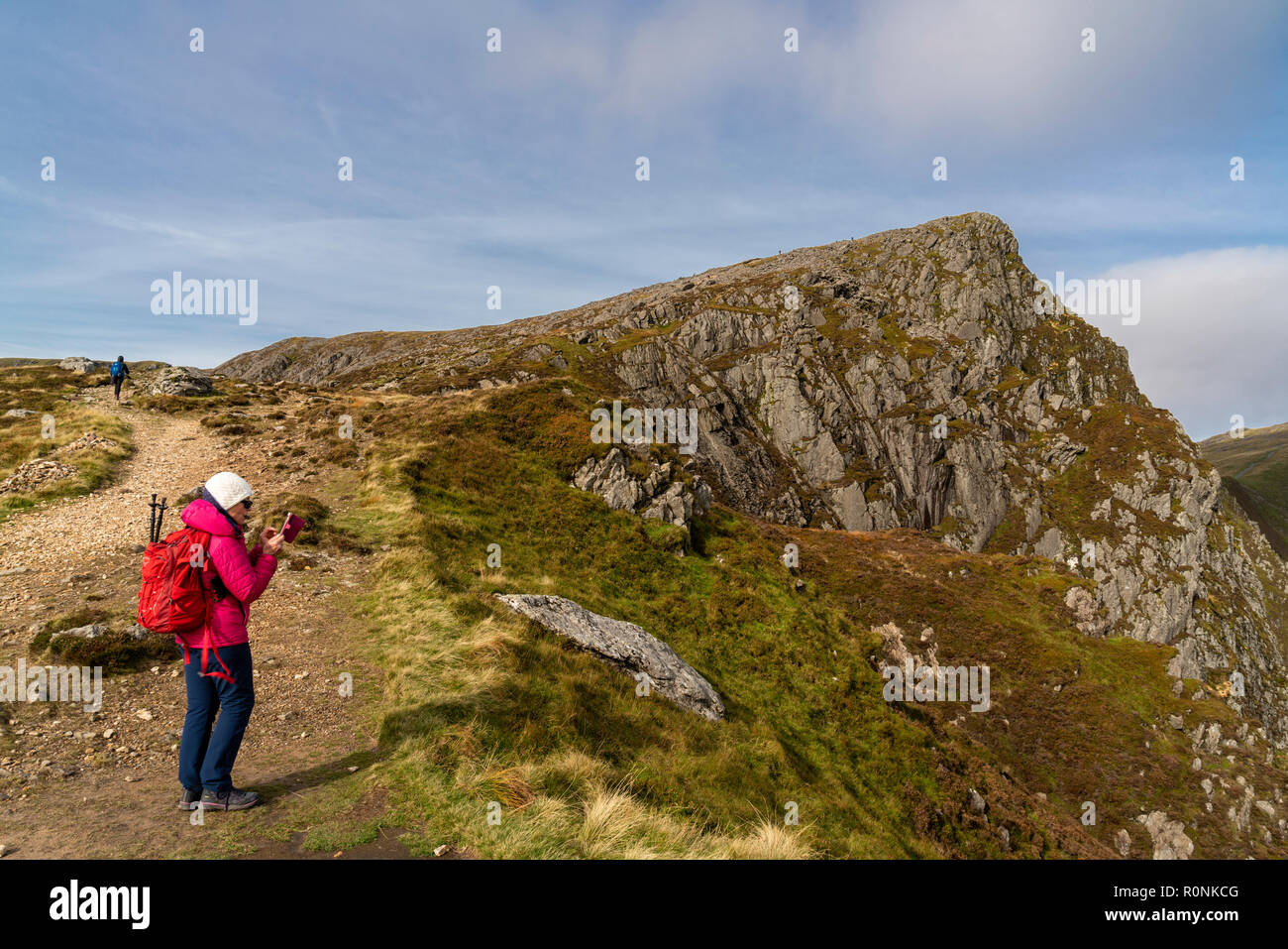 Eine Frau, die ein Foto auf Ihrem Mobiltelefon auf Cadair Idris in Snowdonia National Park, Wales, Großbritannien Stockfoto