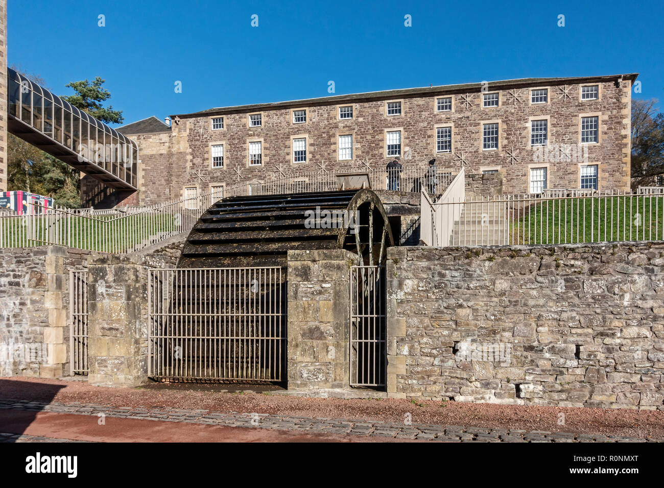 Wasser Rad Mühle 3 mit Institut in New Lanark Mühlen Weltkulturerbe durch den Fluss Clyde in Lanark Lanarkshire Schottland Großbritannien Stockfoto