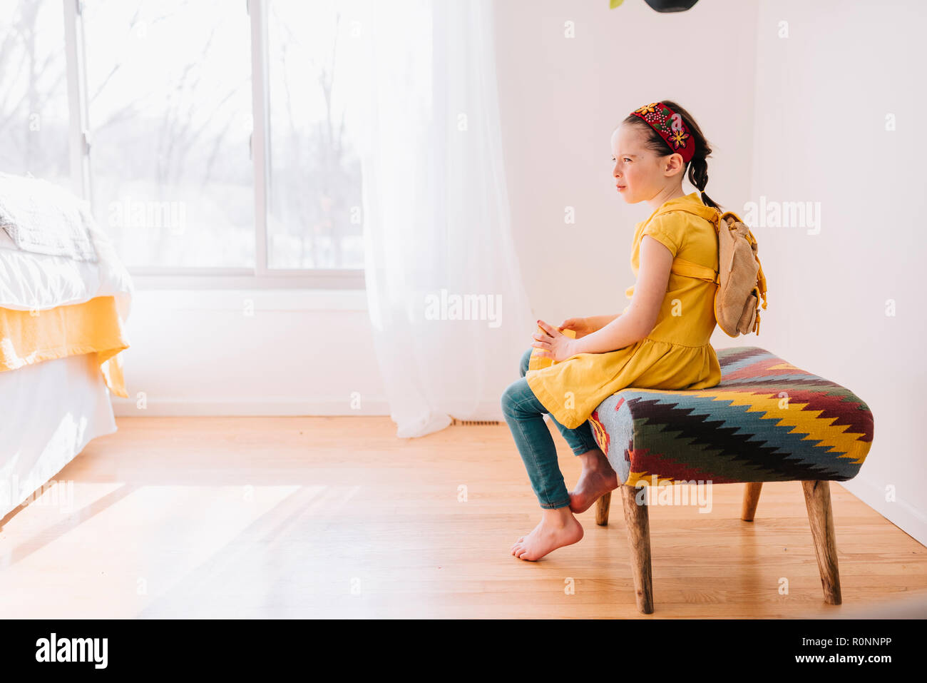 Portrait eines Mädchen sitzt auf einem Hocker mit einem goldenen Geschenkgutschein Stockfoto