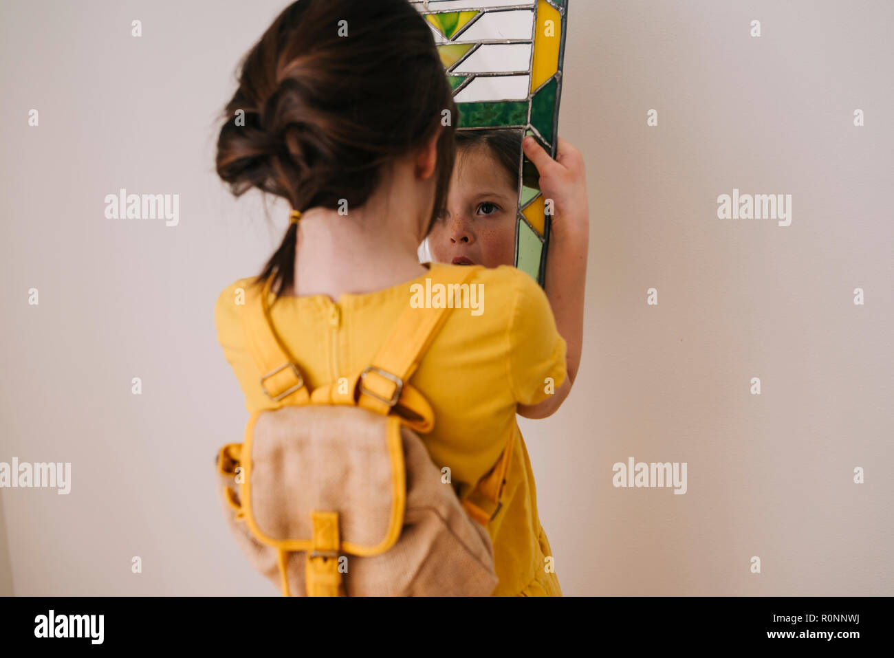 Rückansicht eines Mädchen an ihr Spiegelbild in einem Spiegel zu betrachten Stockfoto