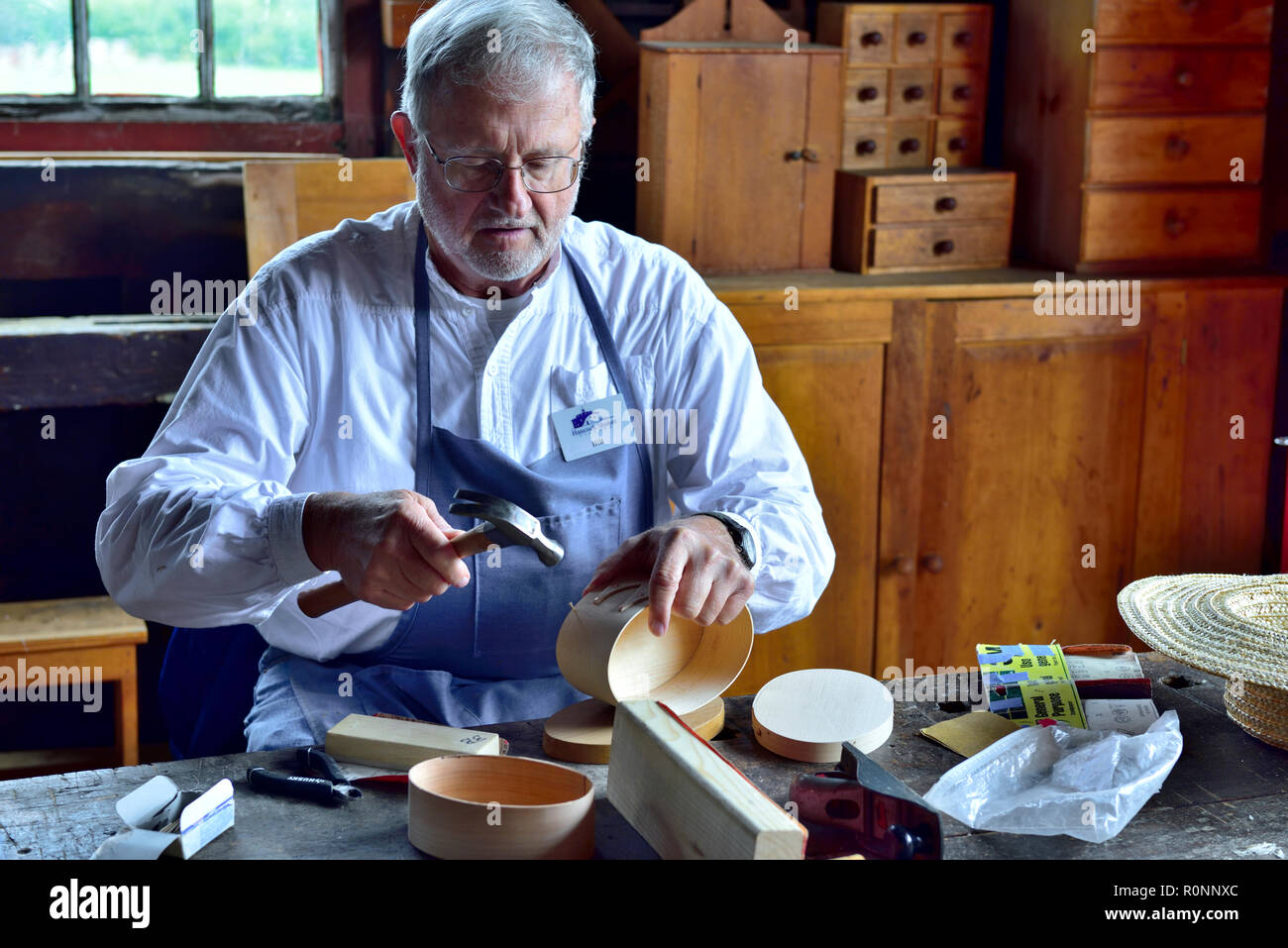 In Hancock Shaker Village Holzbearbeitung Workshop mit Mann, einem traditionellen ovalen Shaker Holzkiste Pittsfield MA, USA Stockfoto