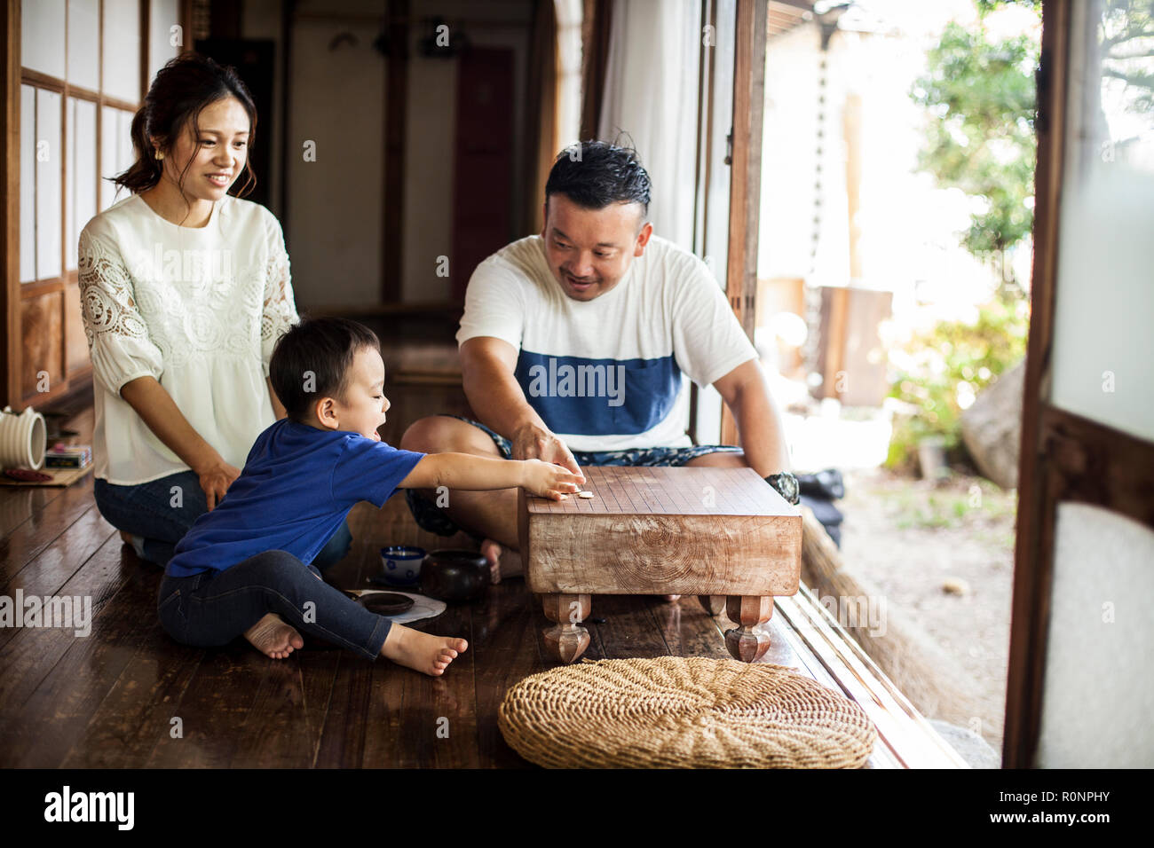Japanische Frau, Mann und der kleine Junge sitzt auf dem Boden auf der Veranda der traditionellen japanischen Haus, Spielen gehen. Stockfoto