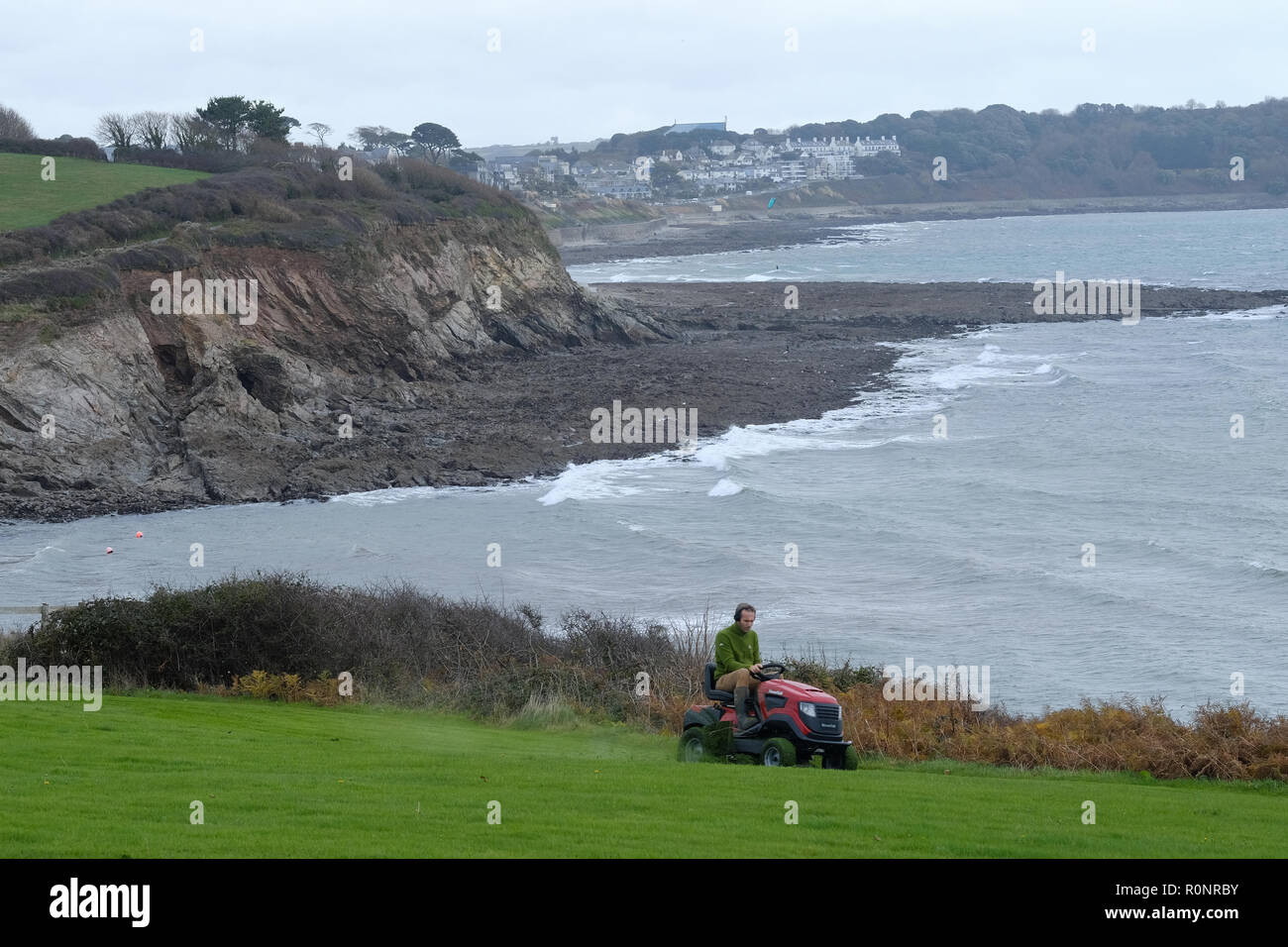 Ein Mann mähen Rasen durch das Meer in Cornwall. Stockfoto