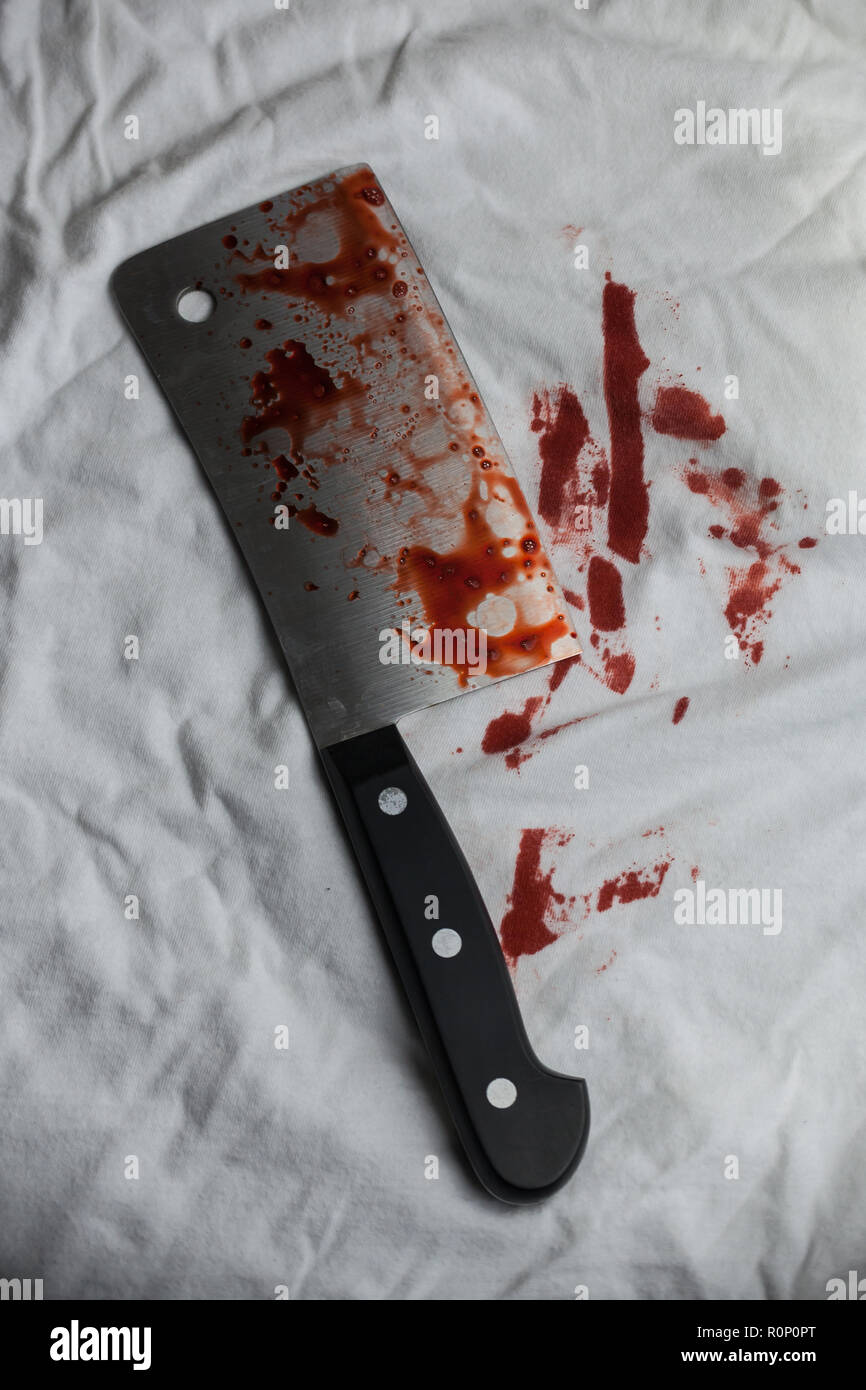 Ein blutiges Fleisch Cleaver sitzt auf einem weißen T-Shirt. Stockfoto