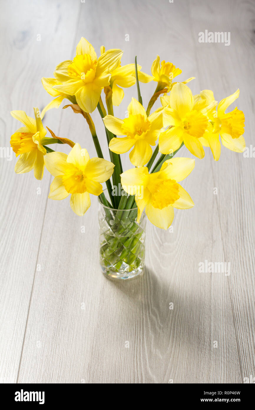 Strauß gelber Narzissen im Glas Vase auf grauen Schreibtisch aus Holz  Stockfotografie - Alamy